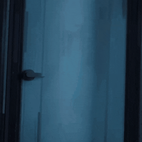 a girl in a white shirt and pink skirt stands in a doorway