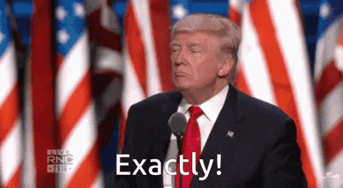 donald trump is giving a speech in front of american flags and saying exactly