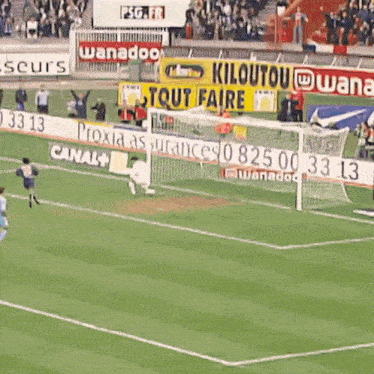 a soccer game is being played on a field with advertisements for canal and wanadoo