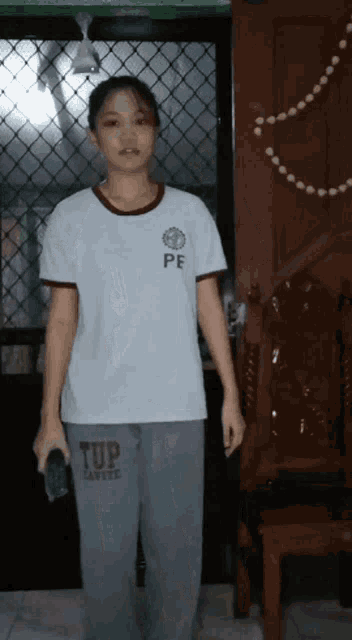 a girl wearing a t-shirt with pe on it