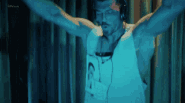 a man wearing headphones and a shirt with the number 23 on it is in a dark room