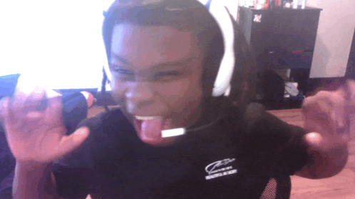 a man wearing headphones and a shirt that says z on it sticks his tongue out