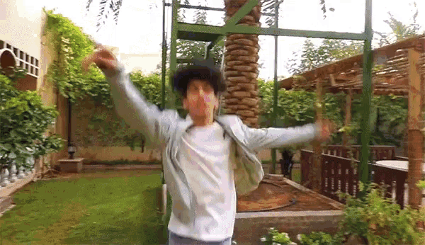 a man with his arms outstretched in a garden