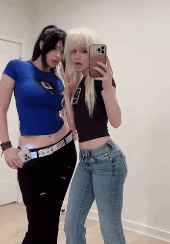 a woman taking a selfie with her phone while standing next to another woman