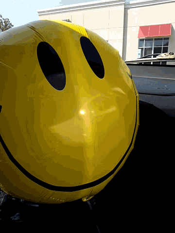 a large yellow smiley face balloon is sitting on a table