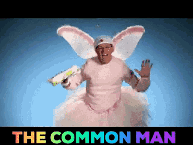 a man in a fairy costume is holding a gun and the words " the common man " are above him