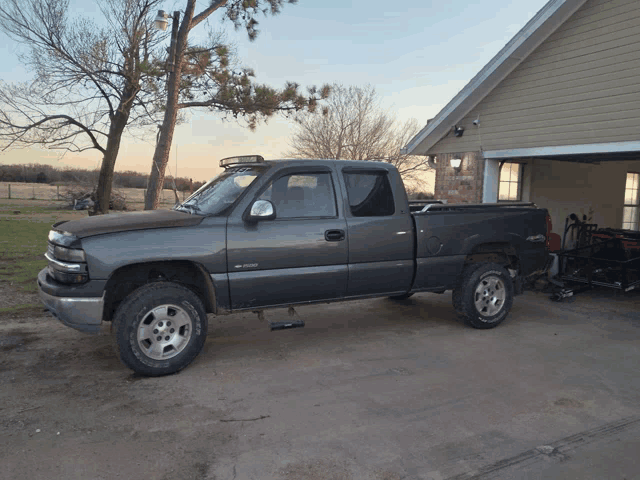 a gray pickup truck is parked in front of a house