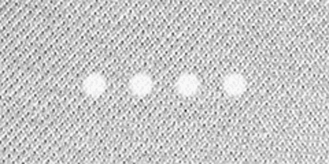 a close up of a white fabric with three white dots .