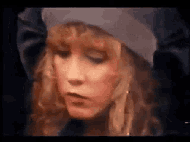 a close up of a woman 's face with a hat on .