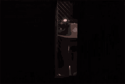 a scary face is visible through a window with a fence in the background