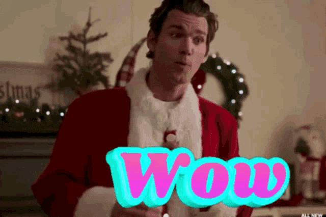 a man in a santa suit has the word wow written in pink letters