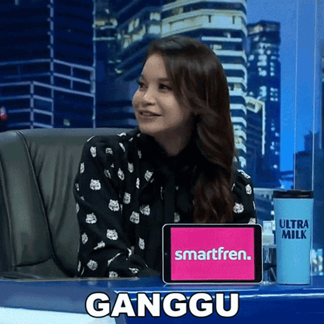 a woman is sitting in front of a smartfren screen