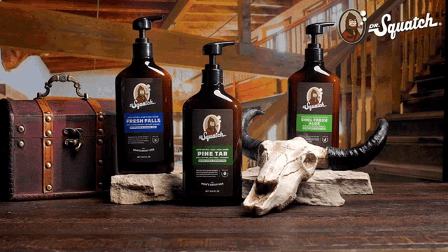 three bottles of squatch products are sitting on a wooden table