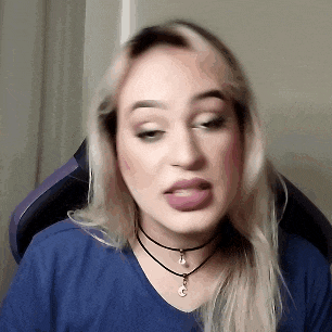 a woman wearing a choker and a blue shirt is making a face