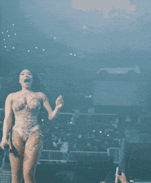 a woman in a very revealing dress is standing in front of a crowd