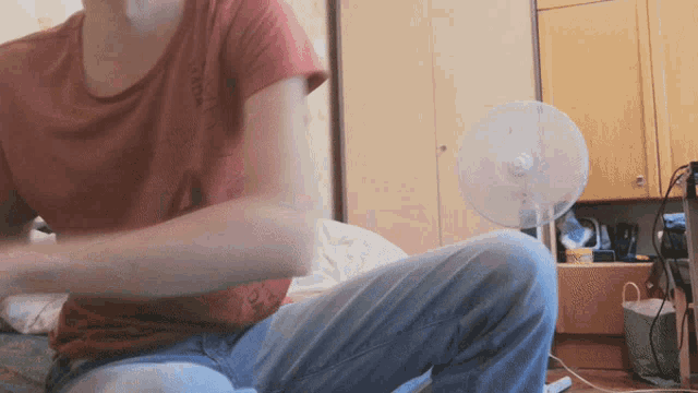 a person sitting in front of a fan with a red shirt that says ' i love you '