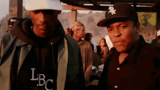two men are standing next to each other and one has a lbc sweatshirt on