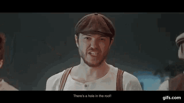 a man with a beard is wearing a hat and suspenders and singing .