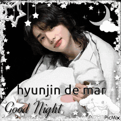 hyunjin de mar is laying in bed with a pillow and a blanket .
