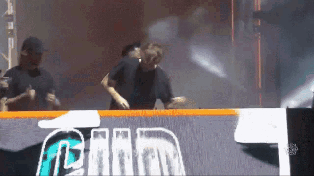 a man is dancing in front of a sign that says ' gmm ' on it