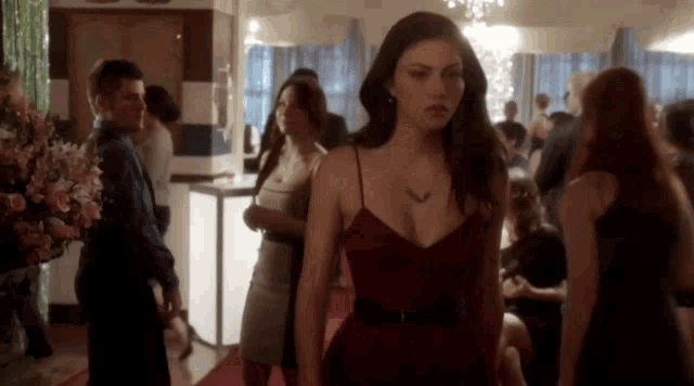 a woman in a red dress is walking down a red carpet