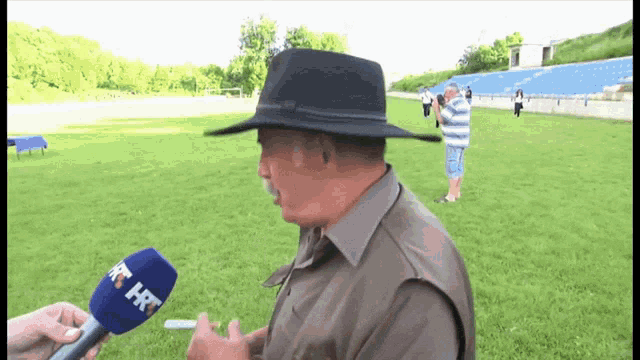 a man wearing a hat is being interviewed by a microphone that says rt hr