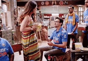 a group of people are gathered in a room including a man wearing a shirt that says star