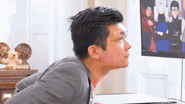 a man is looking at a computer screen with a cartoon on it