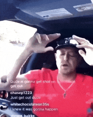 a man in a red shirt is sitting in a car