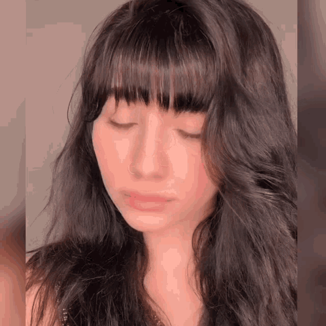 a close up of a woman 's face with closed eyes