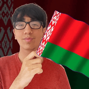 a man wearing glasses holds a red green and white flag in front of his face