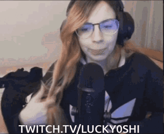 a woman wearing headphones and glasses is talking into a microphone with the words twitch.tv/luckyyoshi written above her