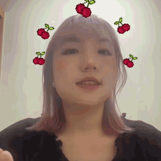 a woman with pink hair has cherry stickers on her face