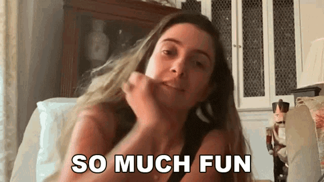a woman is sitting on a couch with the words so much fun behind her