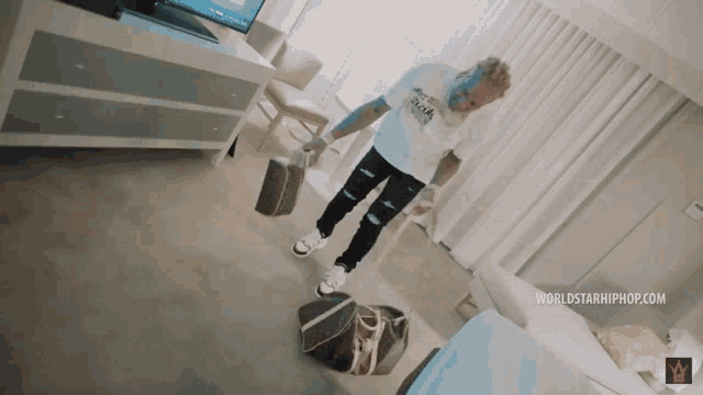 a man standing in a room with a worldstarhiphop.com watermark
