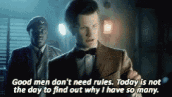 a man in a suit and bow tie is standing in front of a police officer .