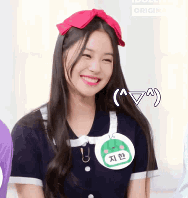 a girl wearing a name tag with the number 16 on it smiles