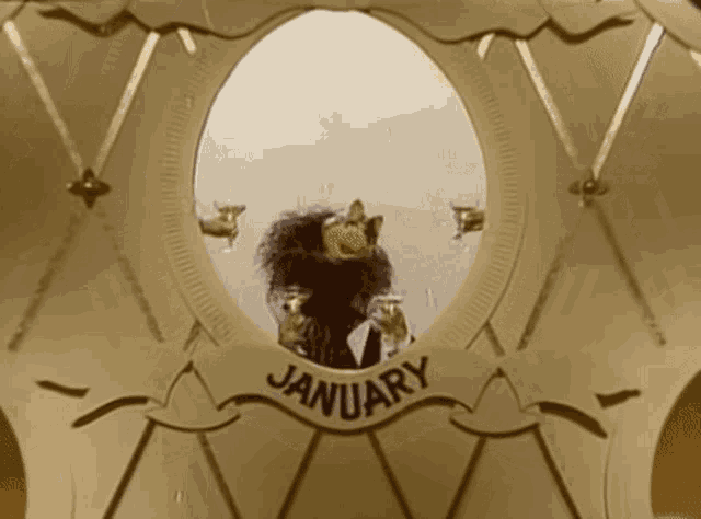 a muppet is holding a glass of wine in front of a sign that reads january