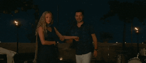 a man and a woman are standing next to each other in a dark room