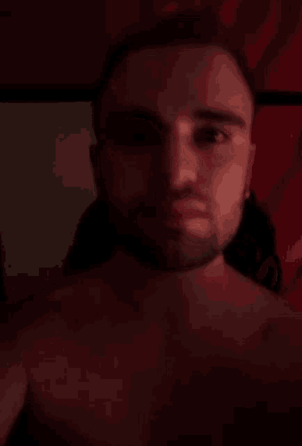 a shirtless man with a beard is taking a selfie