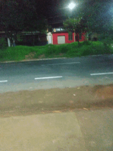 a red truck is parked on the side of the road in front of a sign that says tnt