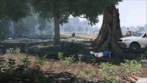 a person laying on the ground under a tree with a shirt that says ' a ' on it