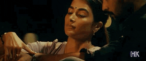 a man is touching a woman 's neck in a movie scene .