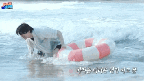 a man is standing in the ocean with a life preserver .