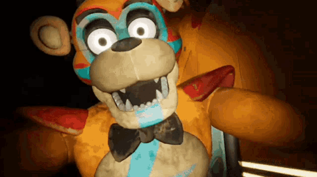 a close up of a stuffed animal with a blue face and wings