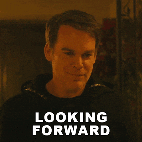 a man in a black shirt is smiling with the words looking forward behind him