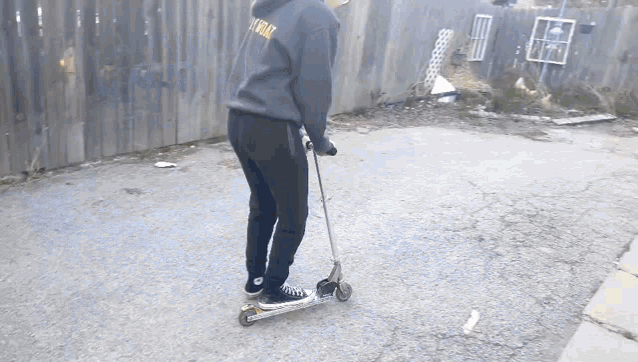 a person riding a scooter with a hoodie that says i 'm okay on it