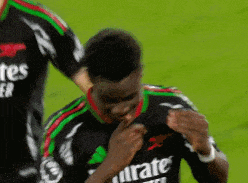 a close up of a soccer player wearing an emirates jersey