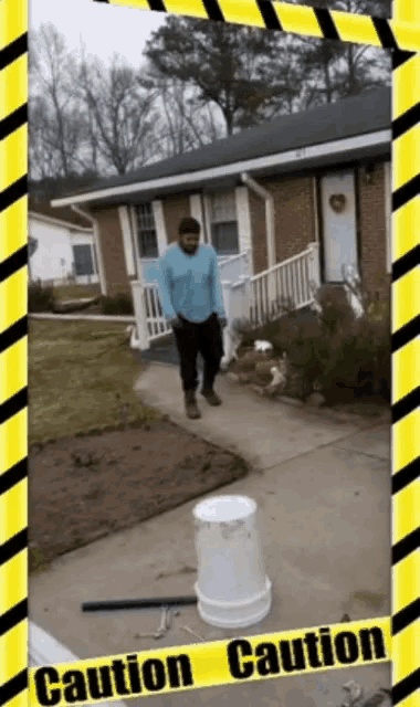 a man standing in front of a house with a yellow and black caution tape around him
