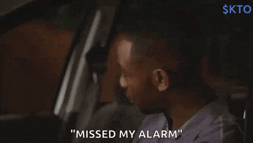 a man is sitting in a car and says " missed my alarm "